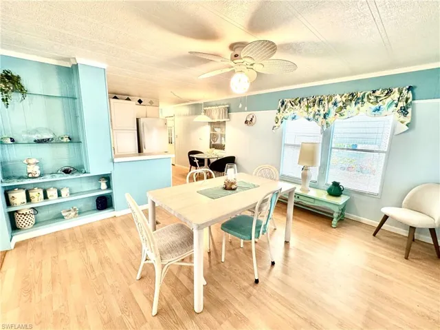 Dining area with ceiling fan, light hardwood / wood-style flooring, and a textured ceiling