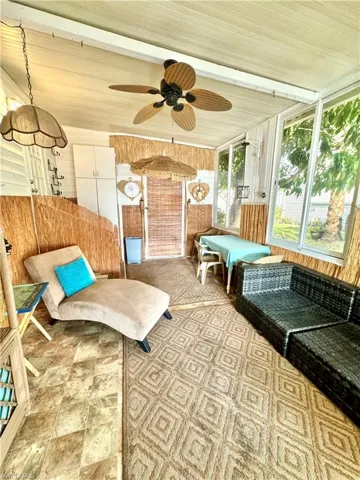 Sunroom / solarium featuring beam ceiling, ceiling fan, and wood ceiling