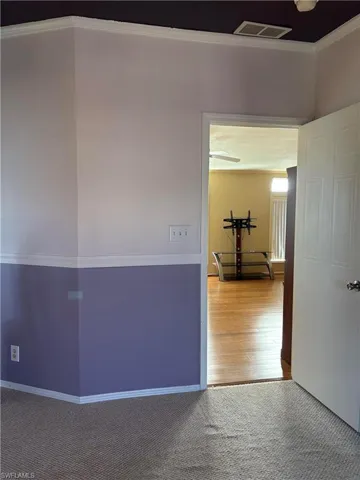 Corridor with crown molding and wood-type flooring