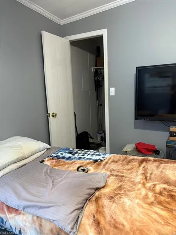 Bedroom featuring a closet and crown molding