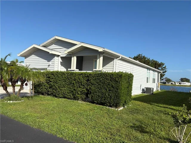 View of side of home with a lawn and central AC unit