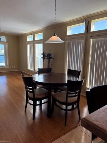 Dining space with crown molding and hardwood / wood-style flooring