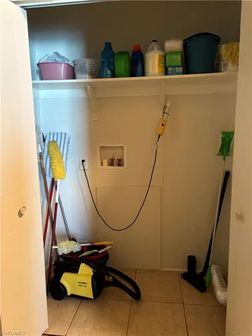 Washroom with hookup for a washing machine and light tile patterned floors