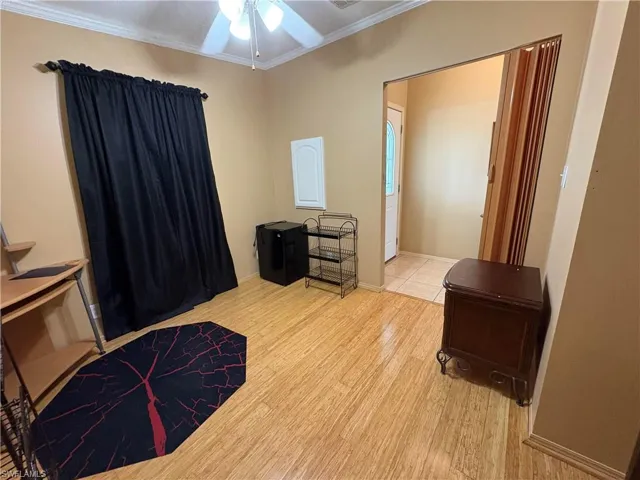 Bedroom with ornamental molding, light hardwood / wood-style floors, and ceiling fan