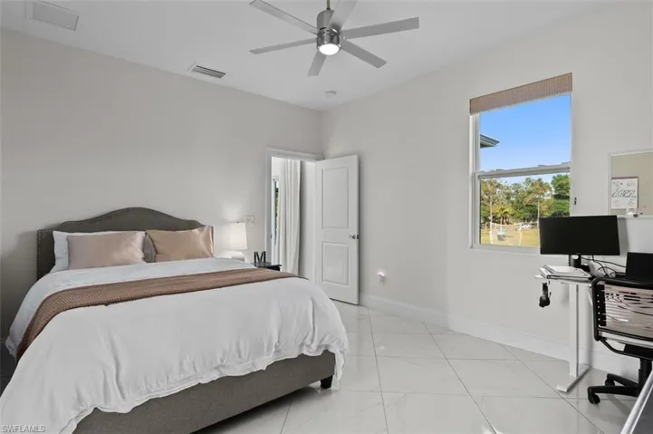Bedroom with a ceiling fan, marble finish floor, visible vents, and baseboards