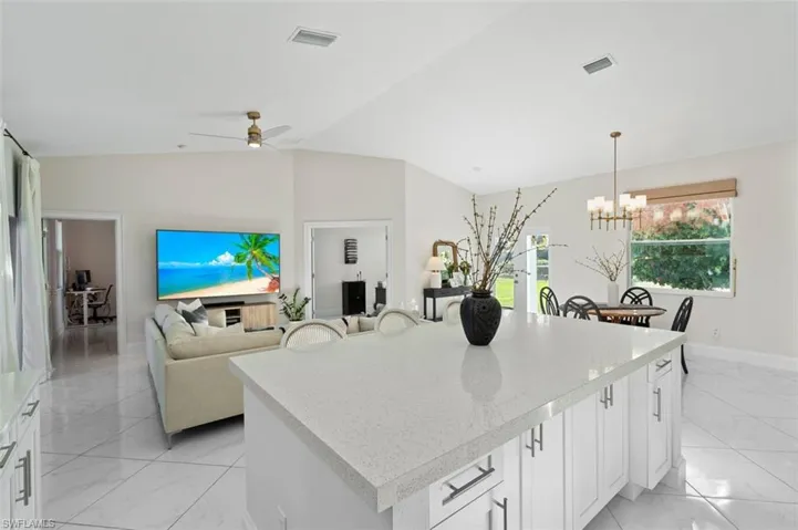 Kitchen with white cabinetry, visible vents, marble finish floor, light countertops, and a center island