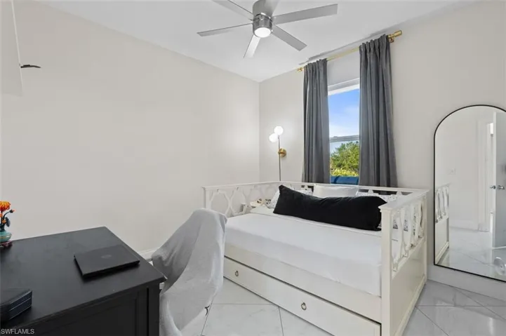 Bedroom featuring marble finish floor and a ceiling fan