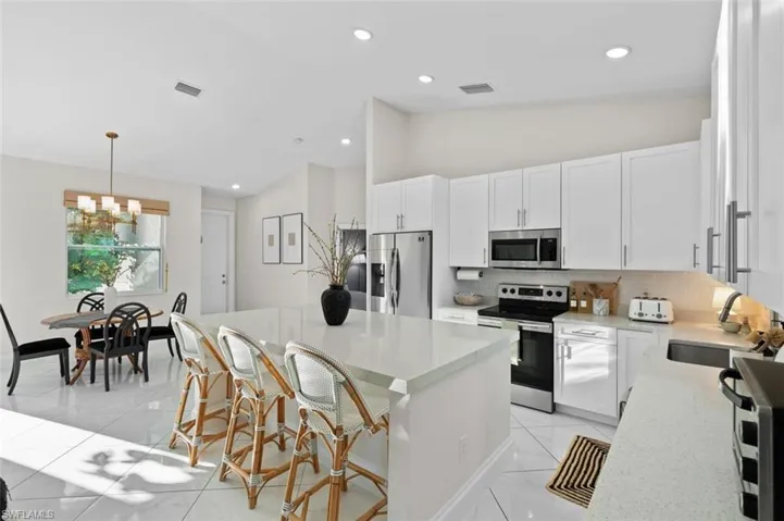 Kitchen featuring lofted ceiling, a sink, visible vents, appliances with stainless steel finishes, and backsplash