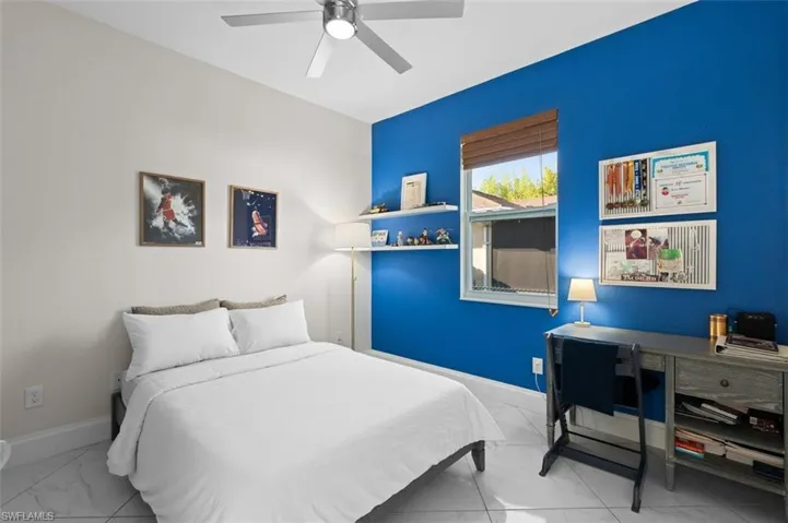 Bedroom featuring marble finish floor, ceiling fan, and baseboards