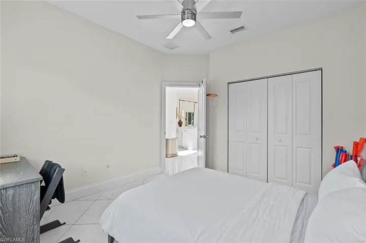 Bedroom featuring marble finish floor, a closet, visible vents, ceiling fan, and baseboards