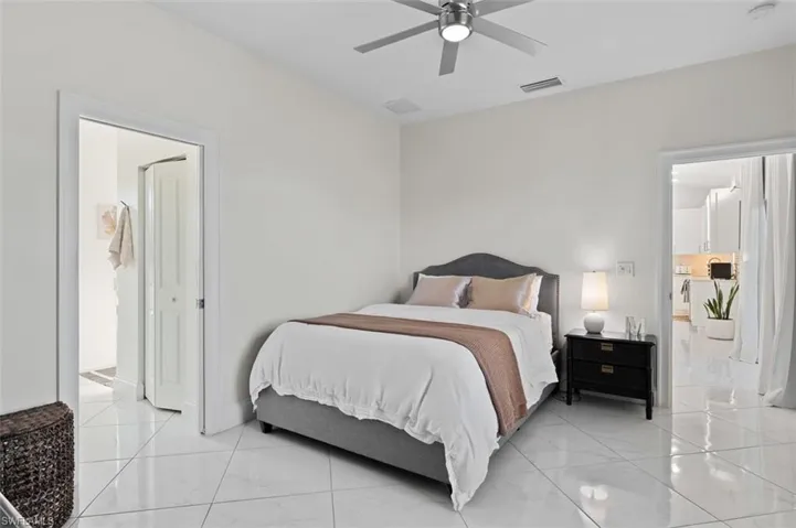Bedroom with marble finish floor, visible vents, and a ceiling fan