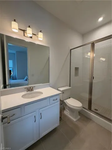 Bathroom featuring a glass-enclosed shower with subway tile surround and a tiled floor