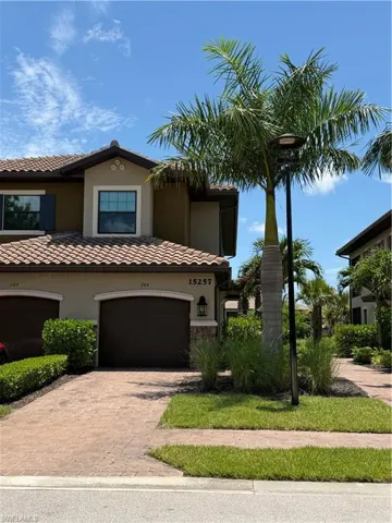 Mediterranean-style residence featuring a tile roof, stucco exterior, and decorative stone accents