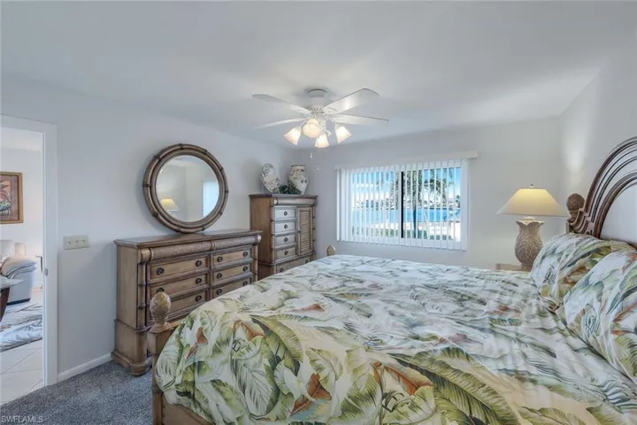 Carpeted bedroom featuring ceiling fan