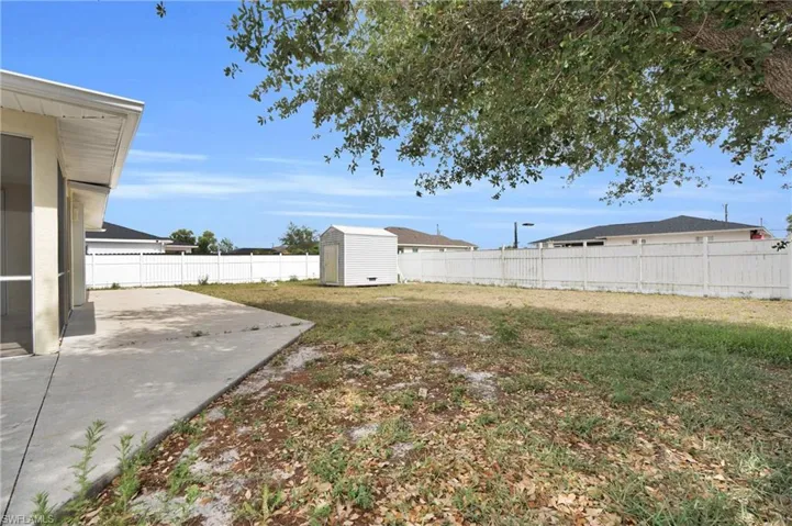 View of yard featuring a storage shed, a patio, an outbuilding, and a fenced backyard