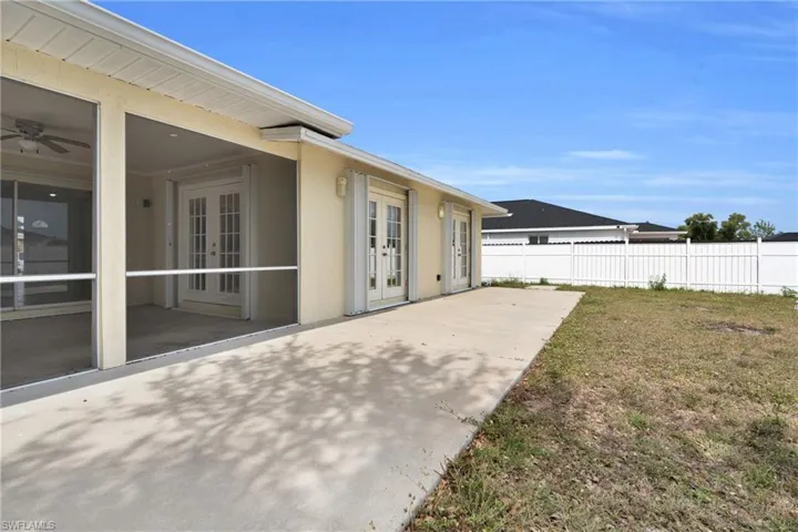 View of yard featuring french doors, fence, and a patio