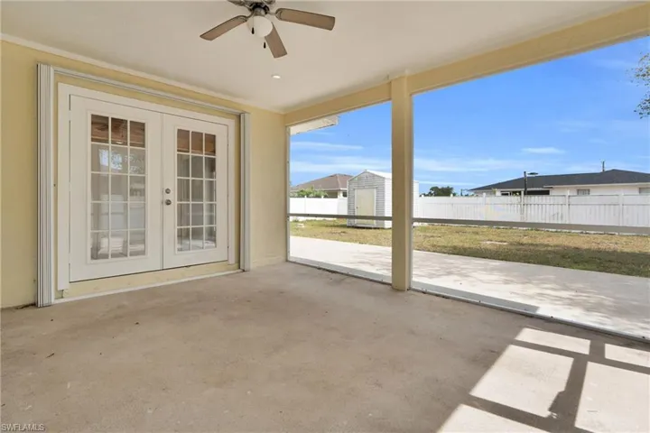 View of patio / terrace with an outbuilding, ceiling fan, fence, and french doors