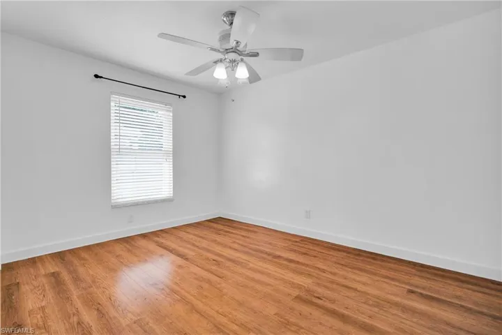 Spare room featuring baseboards, light wood finished floors, and ceiling fan