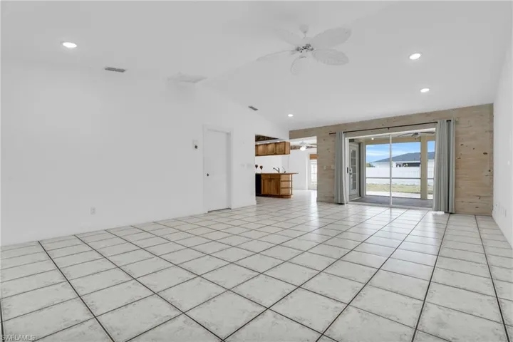 Unfurnished living room featuring recessed lighting, a ceiling fan, visible vents, and lofted ceiling