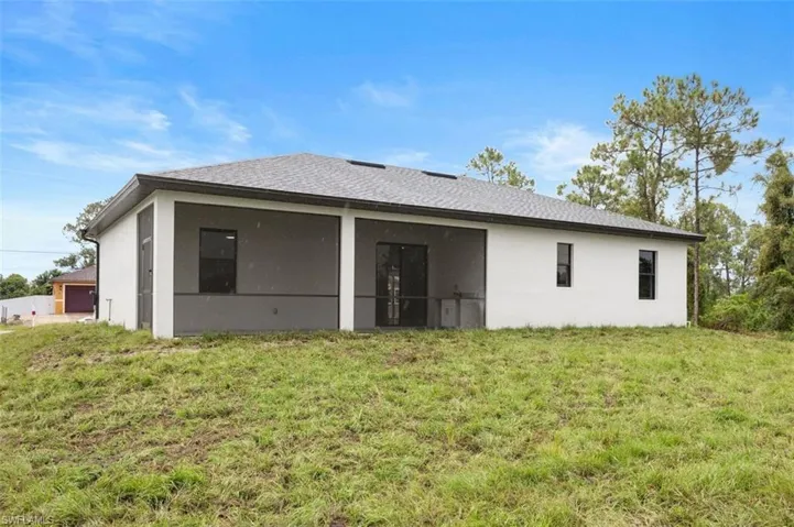 Rear view of property with a yard