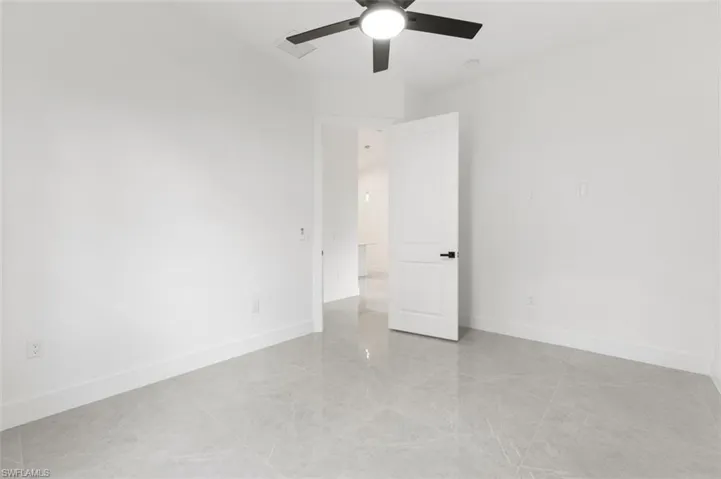 Empty room featuring ceiling fan and light tile patterned floors