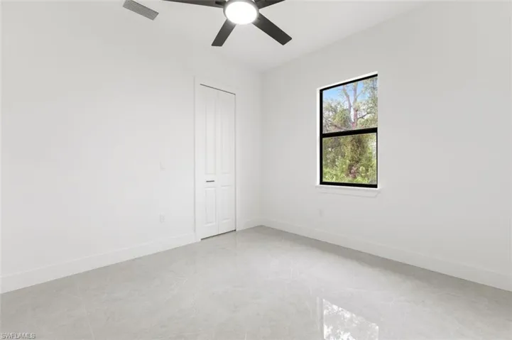 Unfurnished room featuring light tile patterned floors and ceiling fan