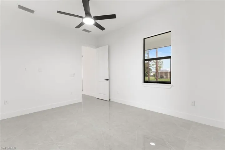 Spare room with light tile patterned flooring and ceiling fan