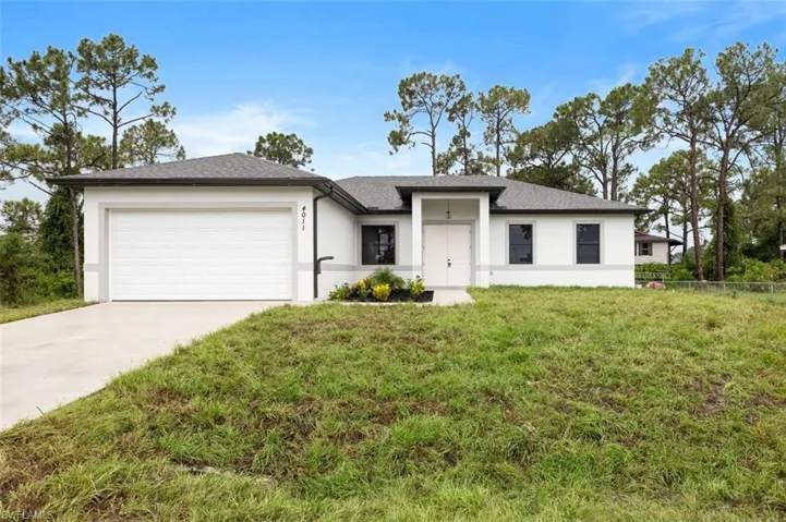 View of front of house featuring a front yard and a garage