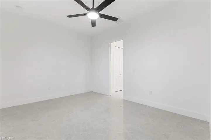 Tiled empty room with ceiling fan