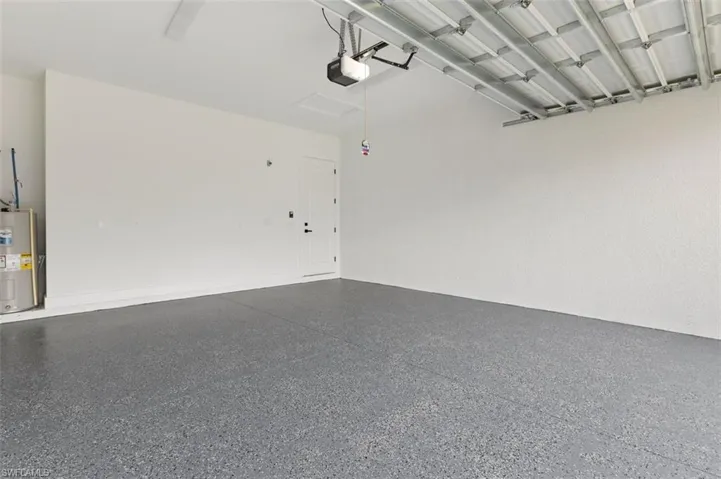 Garage featuring a garage door opener and water heater