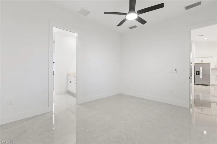 Tiled spare room with ceiling fan