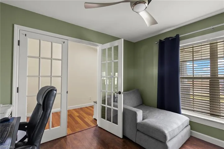 Home office with ceiling fan, hardwood / wood-style flooring, and french doors