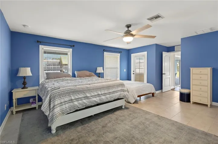 Tiled Master bedroom with ceiling fan and walk in large closet