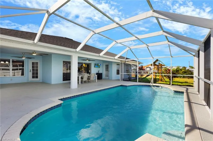 View of pool with a lanai, ceiling fan, and 1/2 bathroom!