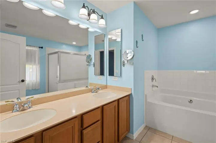 Bathroom with tile flooring, vanity, and separate shower and tub