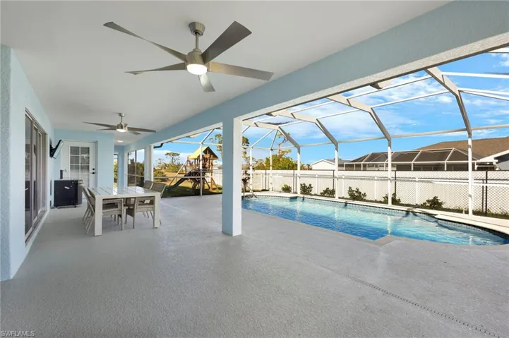 View of swimming pool with ceiling fan, a patio area, and a 1/2 bath on the lanai