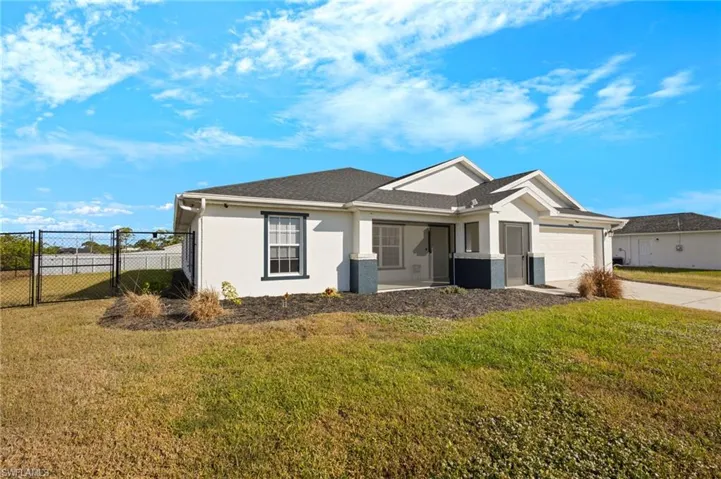 Single story home with a garage and a front yard