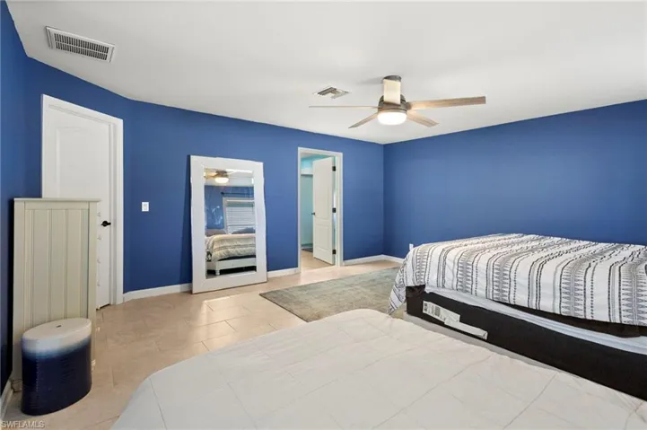 Tiled Master bedroom with ceiling fan and walk in large closet