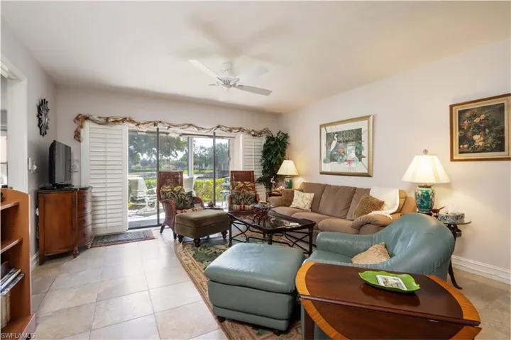 Living area with a ceiling fan and light tile patterned flooring