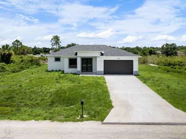 View of front of property featuring a garage and a front yard