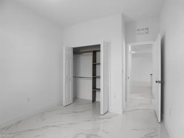 Unfurnished bedroom with a closet and light tile patterned floors