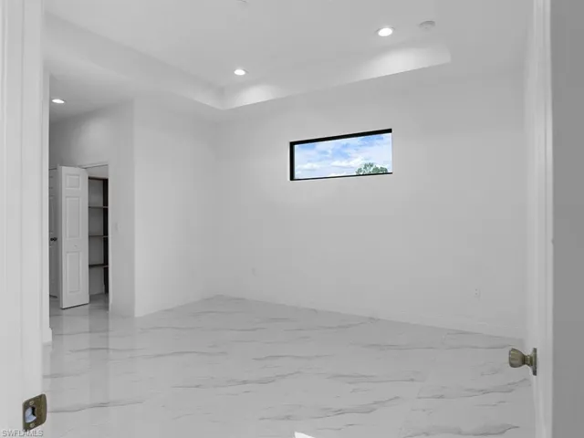 Unfurnished room with light tile patterned flooring and a raised ceiling