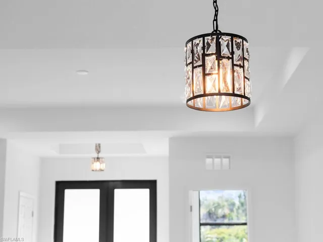Details featuring french doors, a chandelier, and a tray ceiling