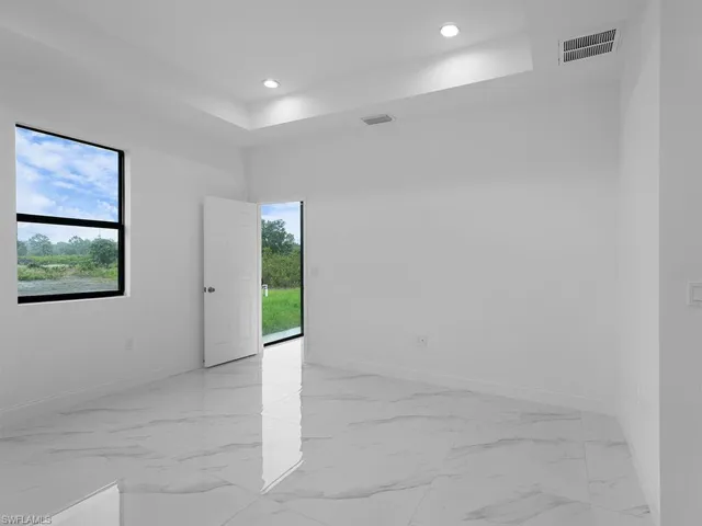 Unfurnished room featuring light tile patterned flooring and a raised ceiling