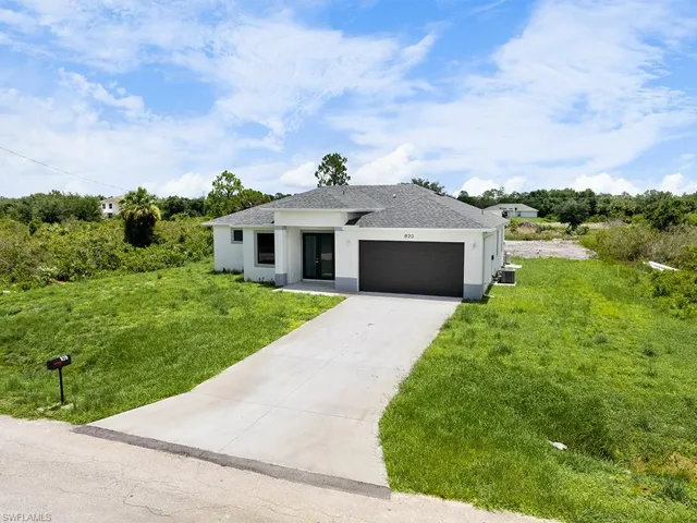 View of front of home with a garage and a front lawn