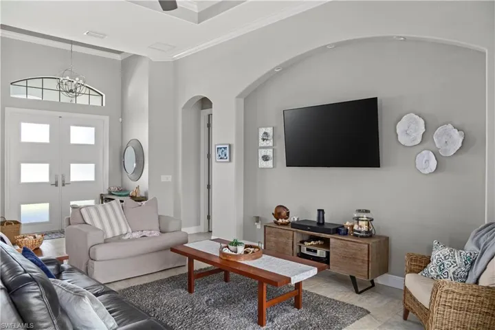 Living room featuring crown molding & tray ceilings