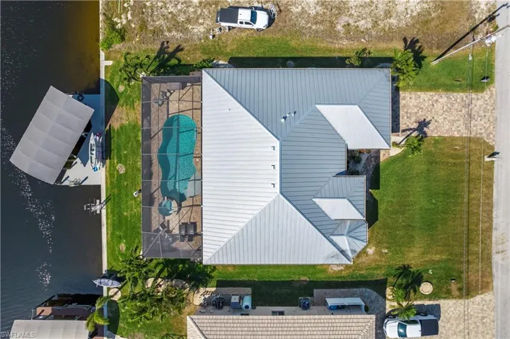 View of property featuring a pool, boat lift and pier.