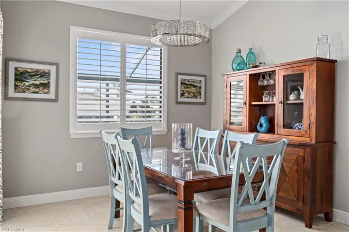 Dining area with Crown Molding & gorgeous chandelier with 90 degree pocket sliders