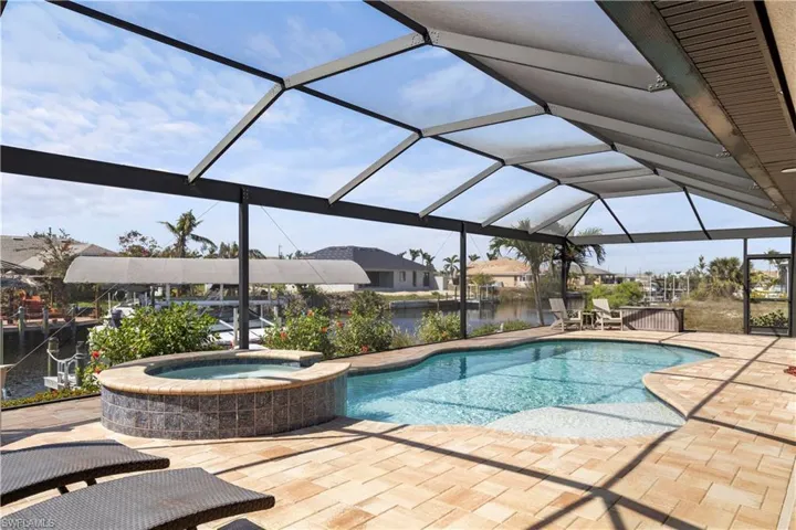 View of swimming pool featuring a hot tub &  water view!
