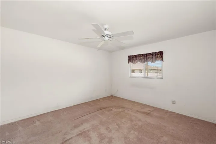 Primary bedroom with a window view of the backyard.